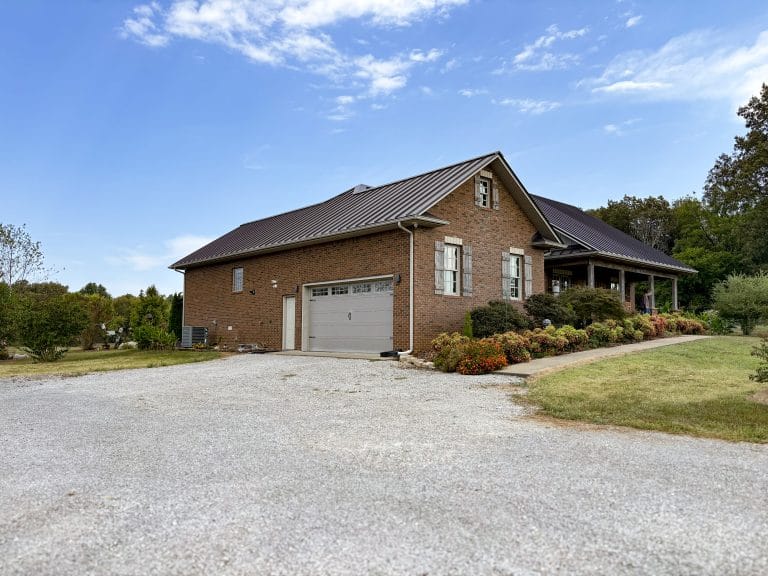 Side view of a brick home with newly installed Standing Seam Roofing. Nate O Roofing offers quality services for both remodel projects and new construction.