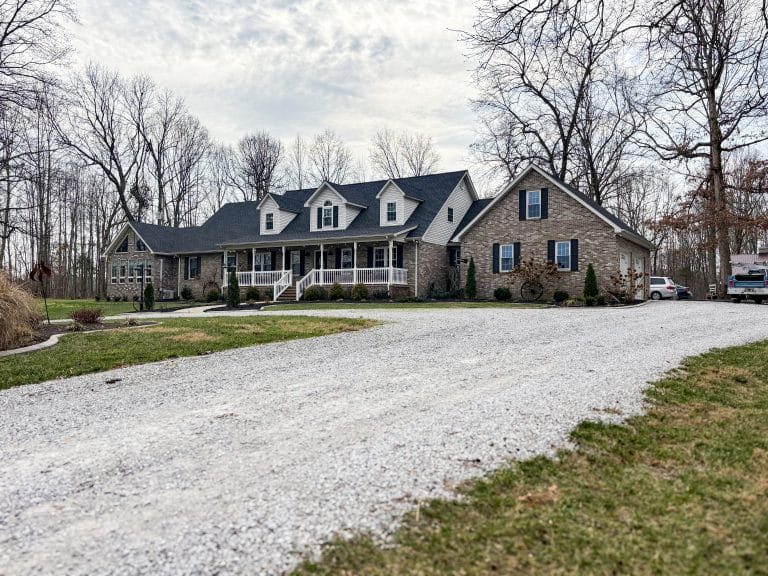 A limestone lane leads up to a brick home where Nate-O Roofing has recently installed new shingles