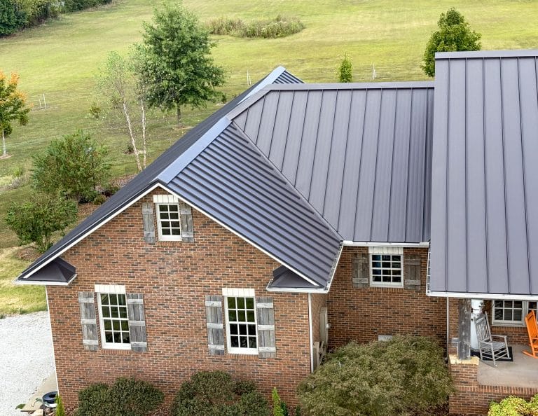 Drone image of a beautiful, dark grey standing seam roof installed on a residential home. Metal roofing on a home near Russellville KY.