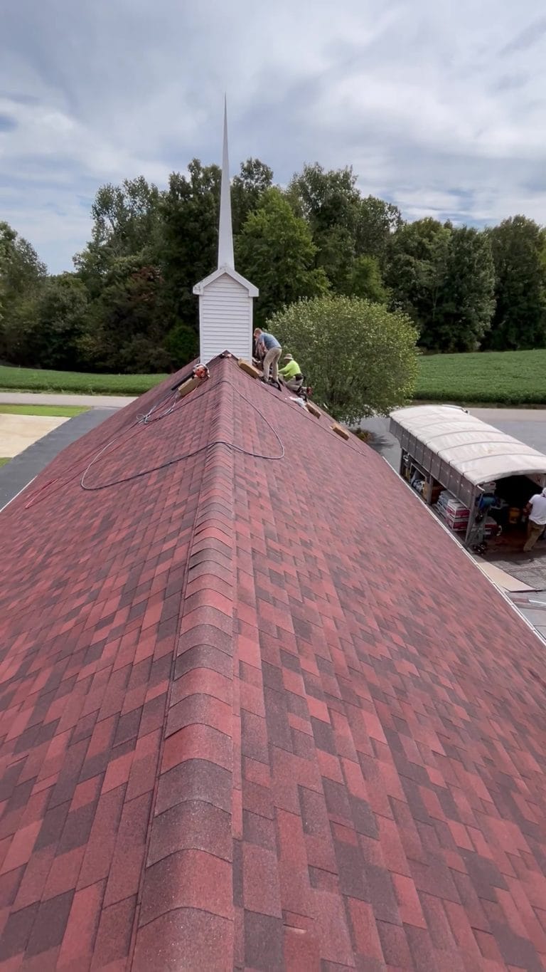Giving the final touches to a newly installed shingle roof