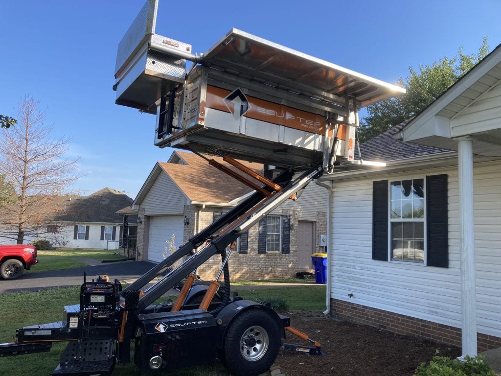 An Equipter machine that makes roof replacement as non-disruptive to the landscaping as possible